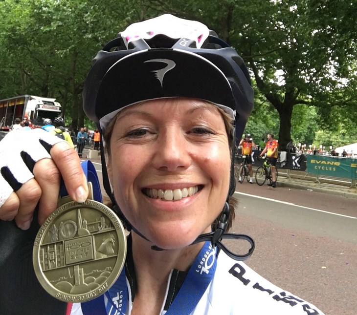 Katy holding up her cycling sponsorship event medal