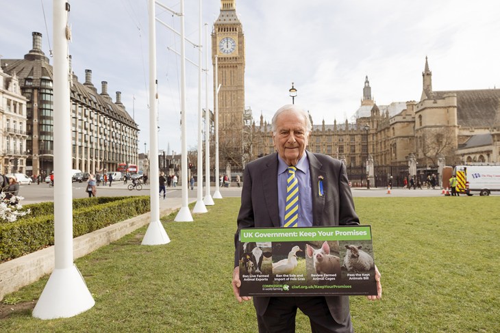 Sir Roger Gale MP holding 'Keep Your Promises' sign with the Houses of Parliament in the background