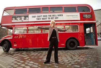 Joanna Lumley standing in front of a large red bus in Trafalgar Square for Ban Live Exports